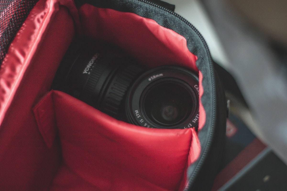 A camera lens tucked inside an open camera bag