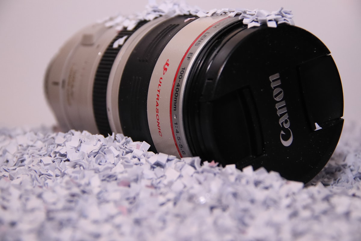 A Canon telephoto lens nestled in shredded packing paper
