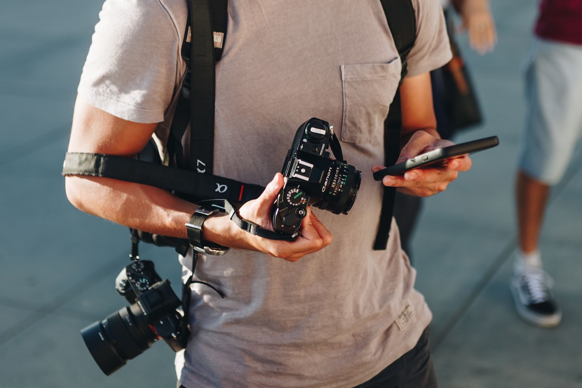 A photographer carrying two cameras on straps